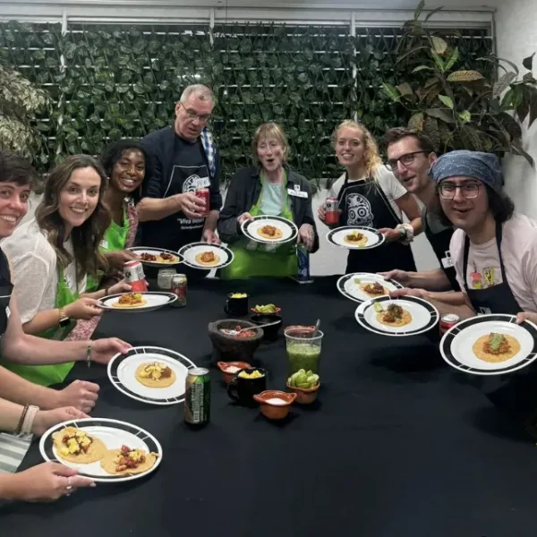 Guests gather around a table enjoying tacos and salsas they prepared during the Mexico City cooking class with chef by Mexico Foodie Tours