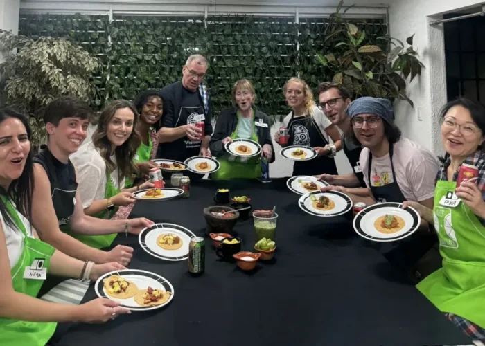 Guests gather around a table enjoying tacos and salsas they prepared during the Mexico City cooking class with chef by Mexico Foodie Tours