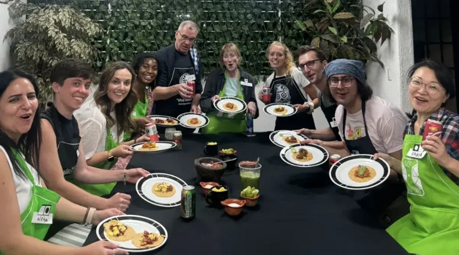 Guests gather around a table enjoying tacos and salsas they prepared during the Mexico City cooking class with chef by Mexico Foodie Tours