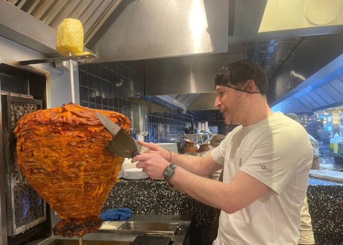 Taquero carving tacos al pastor from a vertical trompo spit during a Polanco taco tour in Mexico City