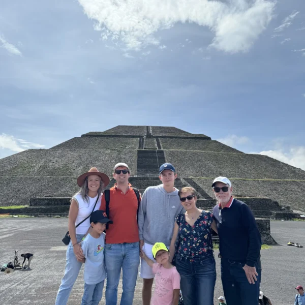 Family group posing in front of the Pyramid of the Sun during a half-day Teotihuacan tour from Mexico City with Mexico Foodie Tours