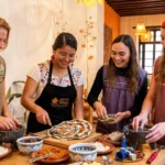Guests preparing antojitos together with a traditional Mexican cook during a cooking class in Mexico City