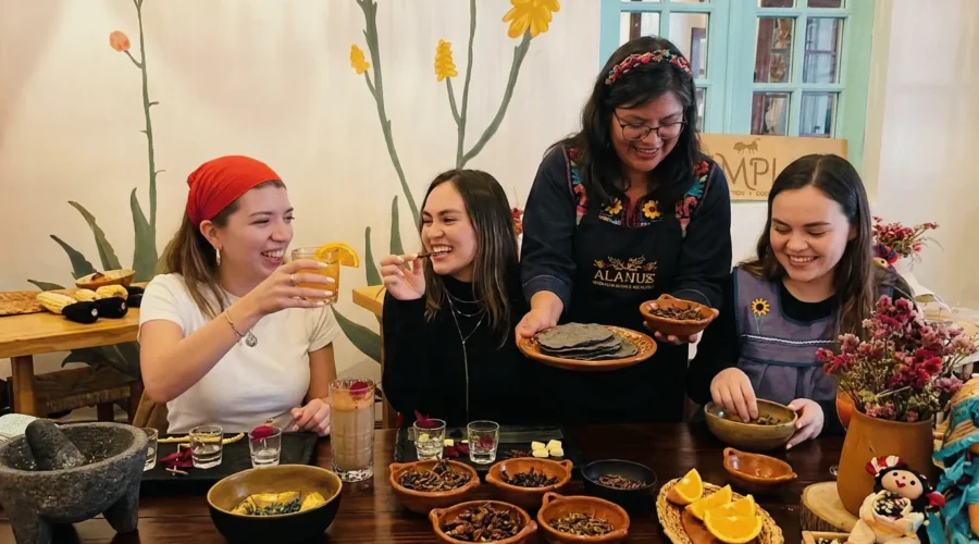 Traditional cook serving a mezcal and edible insects tasting with orange slices to guests