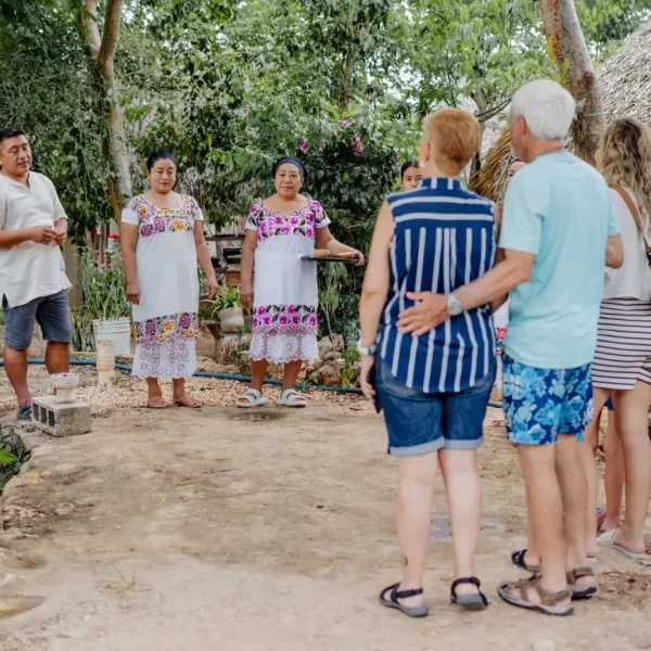 Maya cooks in embroidered dress welcoming travelers to their village in Yucatán on a food tour in Mexico
