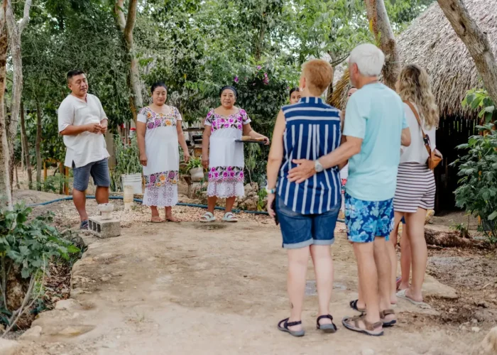 Maya cooks in embroidered dress welcoming travelers to their village in Yucatán on a food tour in Mexico